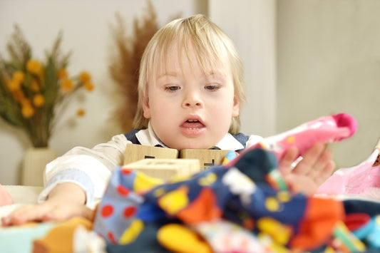 a little girl sitting at a table with a toy