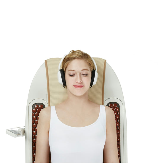 a woman wearing headphones sitting in a reclining chair