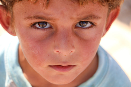A close up of a young boy with blue eyes