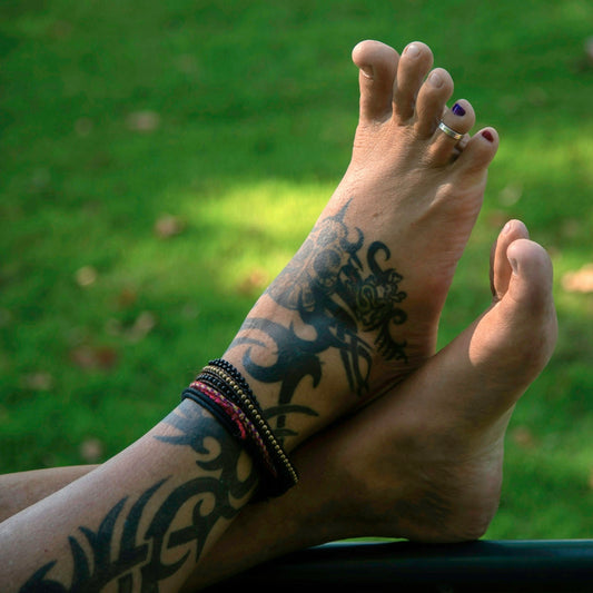 A person with tattoos on their legs sitting in a car