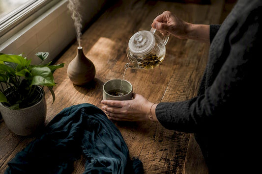 Hands pouring tea for mood regulation