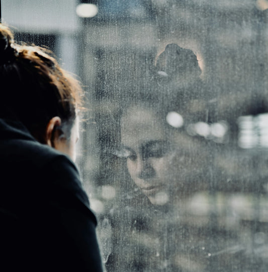woman standing beside glass wall