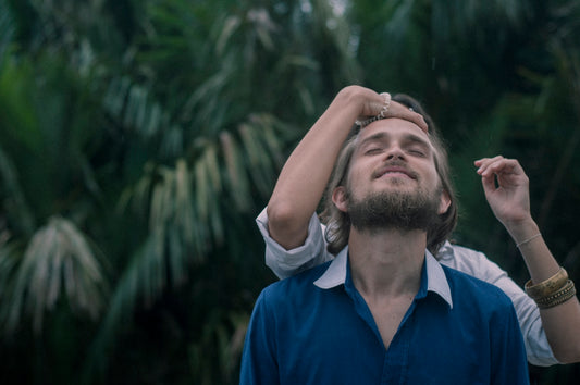 woman touching man in blue shirt's forehead