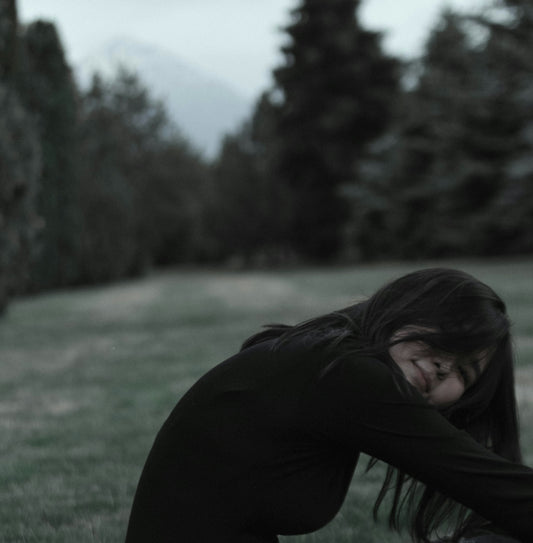 woman leaning forward near trees