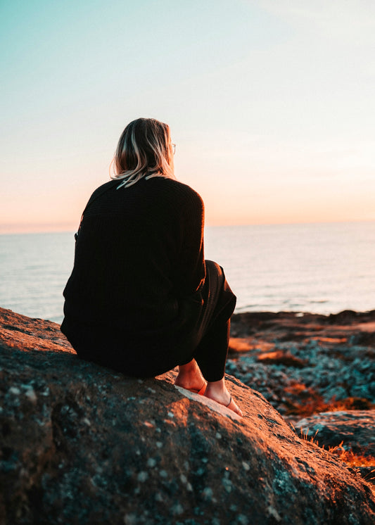 women sitting in a rock during daytime