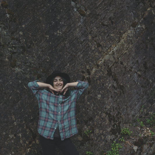 girl smiling wearing blue and red plaid shirt