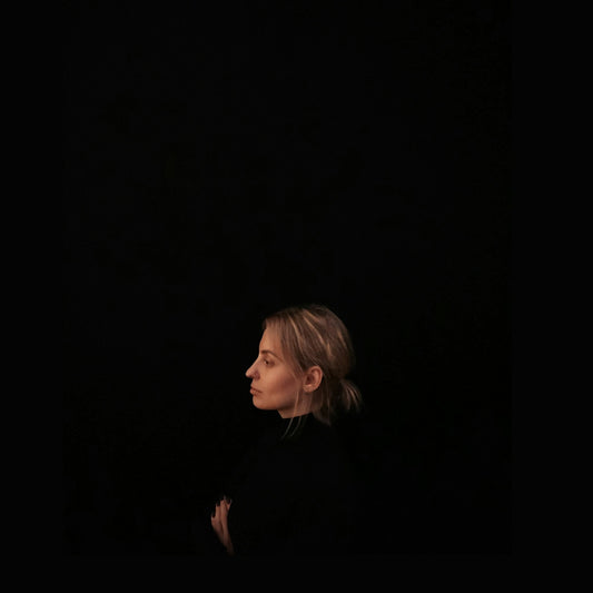 minimalist photography of woman wearing black top facing to the side