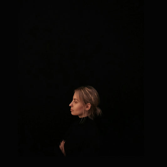 minimalist photography of woman wearing black top facing to the side
