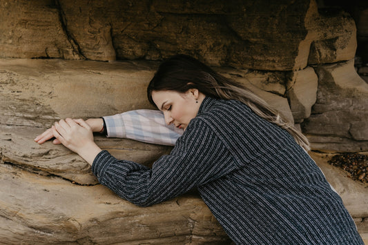 woman in black and white striped long sleeve shirt lying on brown sand