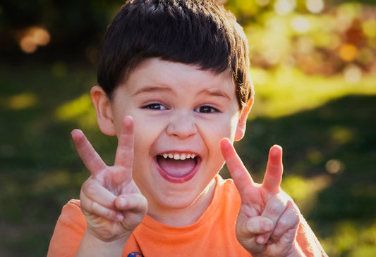 boy in orange crew neck shirt smiling
