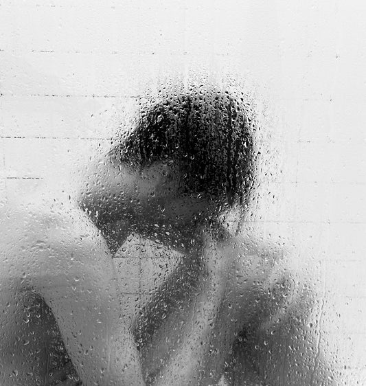 grayscale photo of woman in shower room