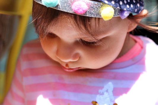 girl in white and red stripe shirt with blue and white floral headband