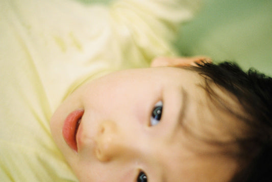 boy lying on yellow textile