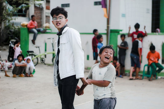 boy in white polo shirt and black pants standing beside boy in white polo shirt during