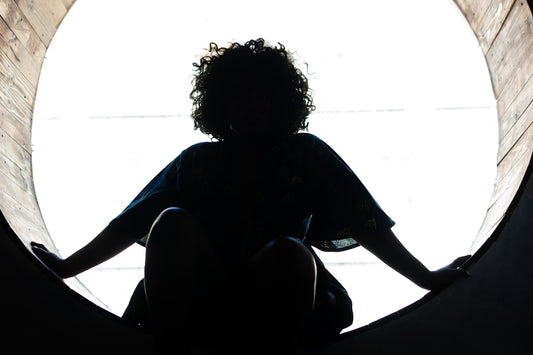 woman in blue shirt sitting on blue textile