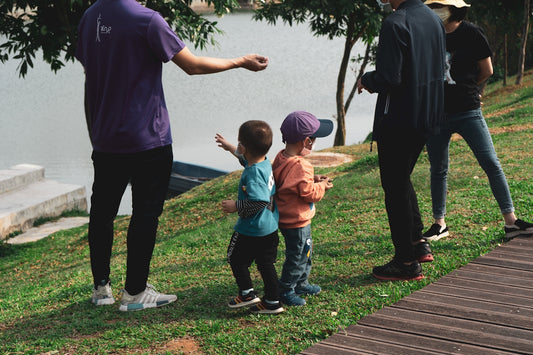 man in blue crew neck t-shirt and black pants holding girl in orange t-shirt