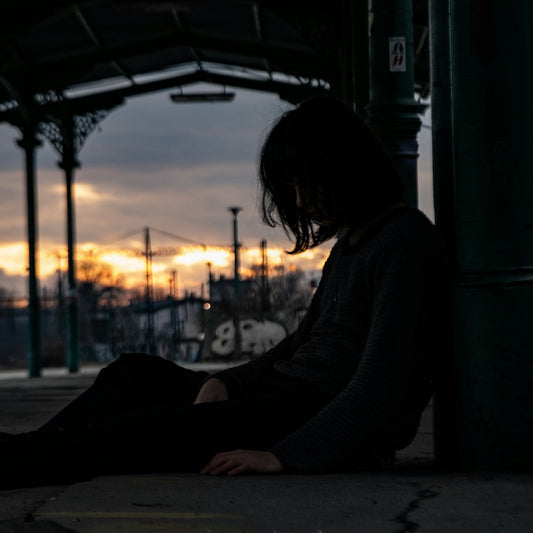 woman in white long sleeve shirt sitting on floor during sunset