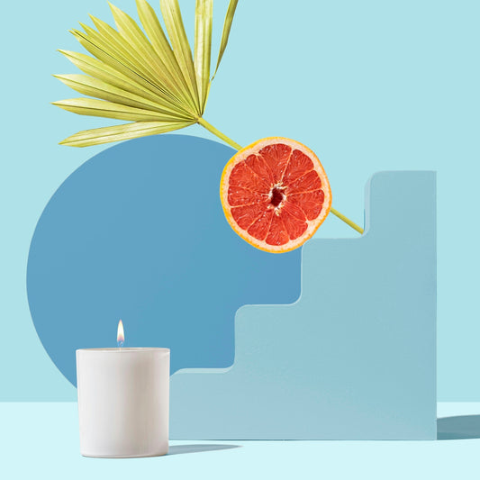 orange fruit beside white pillar candle