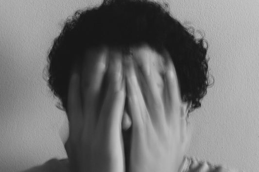 grayscale photo of woman covering her face