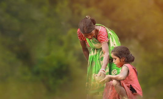 girl in pink dress holding girl in green shirt