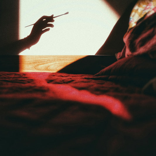 a person is holding a cigarette in their hand