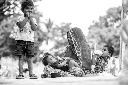 a group of young children standing around a baby carriage