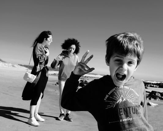a group of people standing on a beach near the ocean
