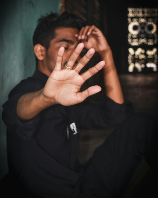 a man sitting down with his hands in the air