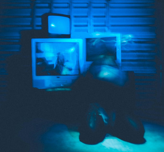 a person laying on a bed in front of a tv