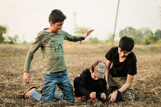 a group of boys kneeling in a field