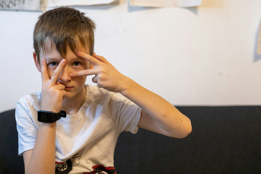a boy with his hands on his face