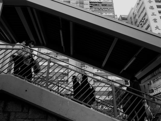 a black and white photo of people walking up stairs