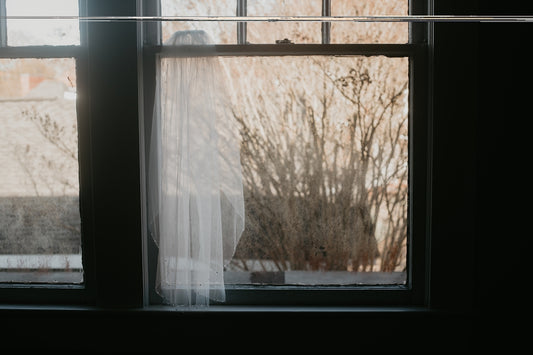 a woman standing in front of a window