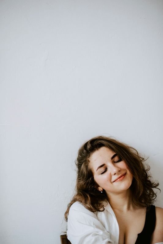 a woman sitting on a chair with her eyes closed
