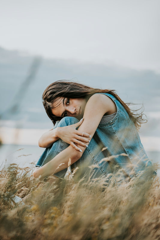 a woman sitting in a field of tall grass