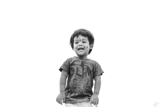 a young boy standing on top of a grass covered field