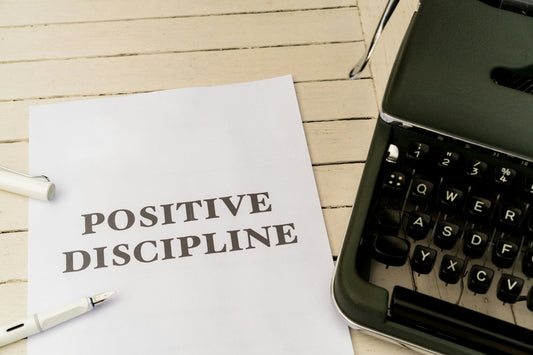 a piece of paper that says positive discipline next to a typewriter