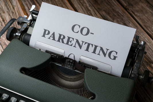 a close up of a typewriter with a paper that says co - parenting