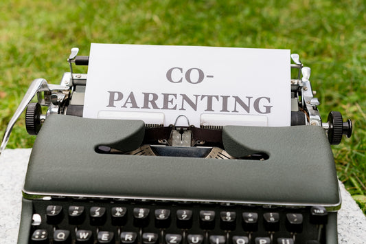 a close up of a typewriter with a paper that says co - parenting