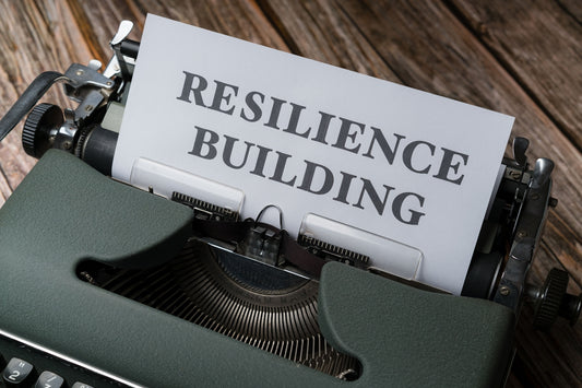 a close up of a typewriter with a paper that reads resilince building