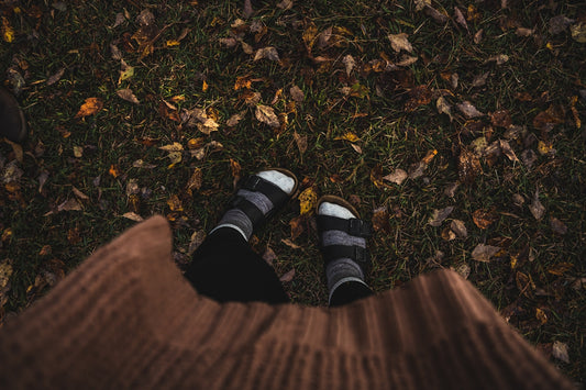 a person standing in the grass with their feet up