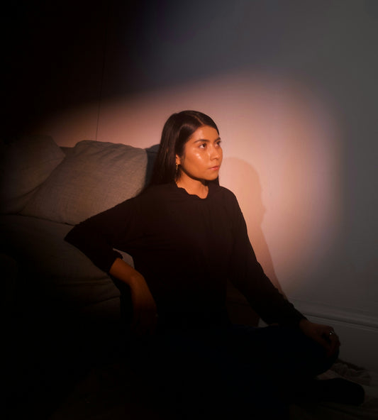 a woman sitting on a couch in the dark