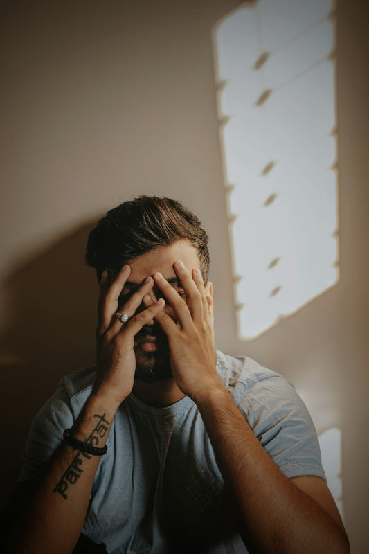 a man covering his eyes with his hands