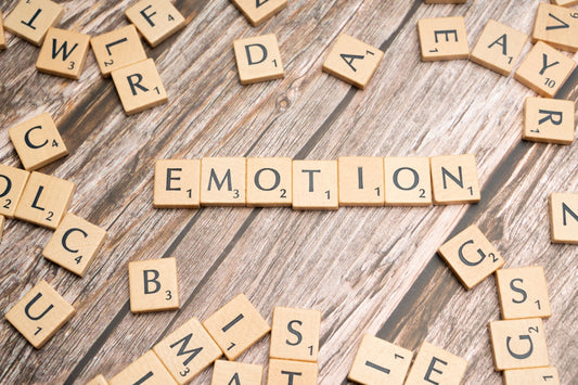 scrabble tiles spelling the word emotion on a wooden surface