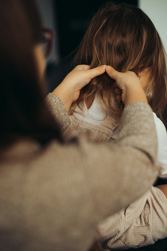 a woman sitting at a table with her hands on her head