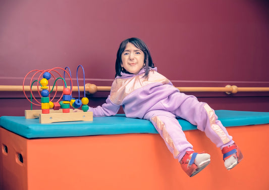 a little girl sitting on top of a blue bench