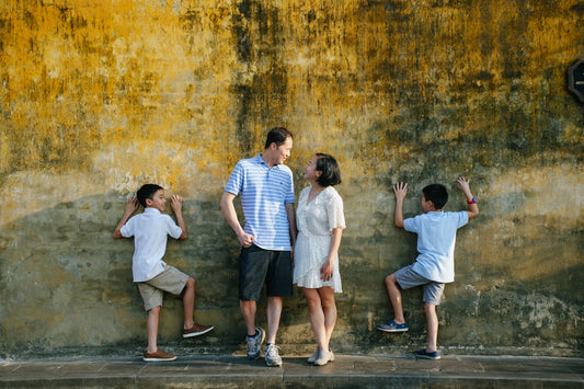 a group of people standing in front of a yellow wall