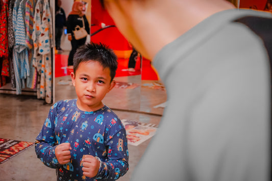 a little boy standing in front of a man