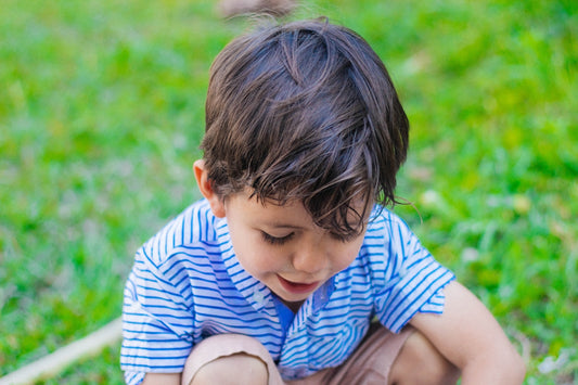 a little boy sitting on the ground playing with a toy