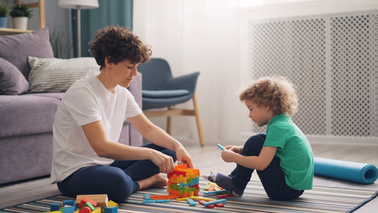 a man and a child playing with blocks on the floor